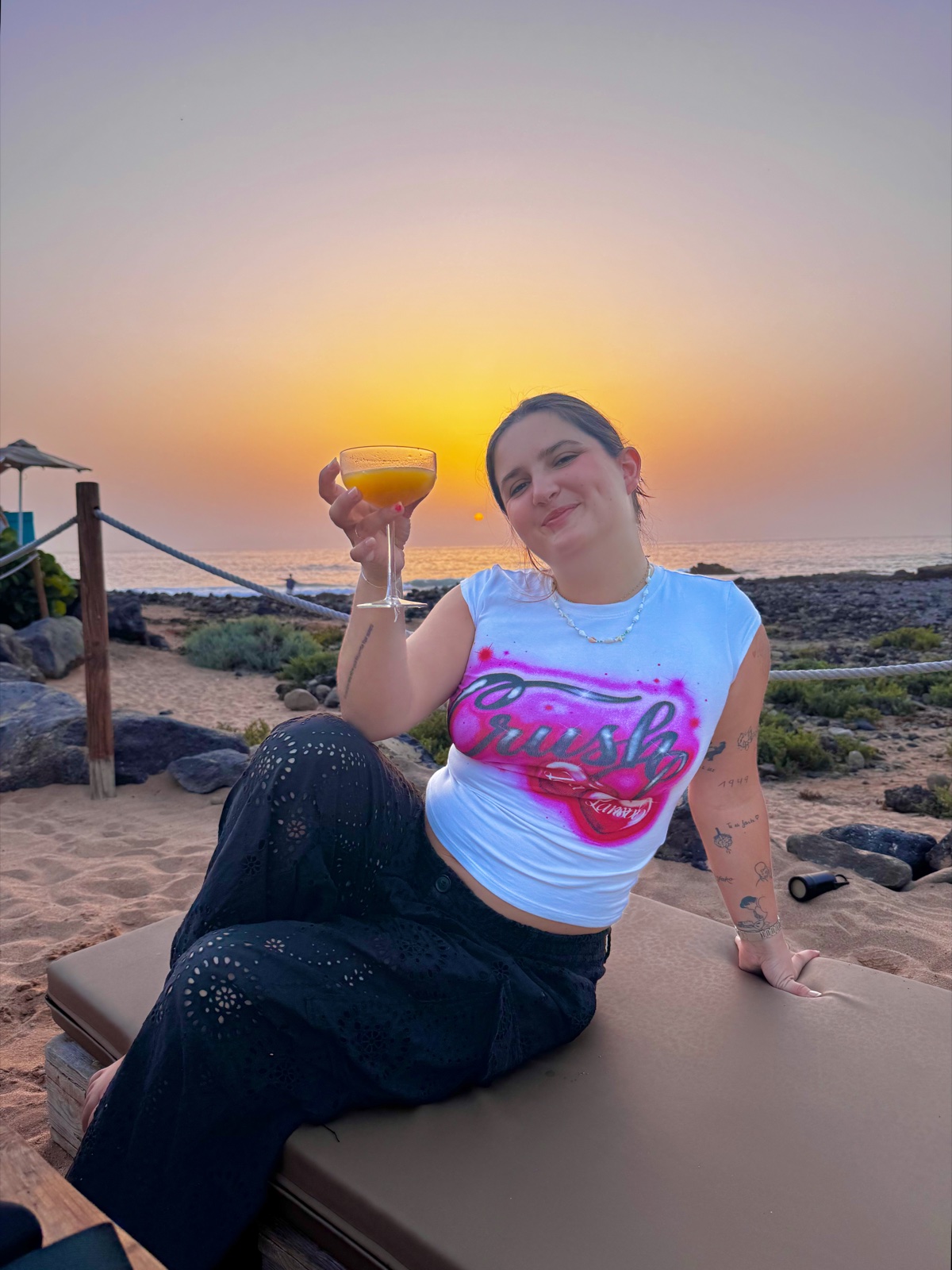 Inès au coucher de soleil, cocktail à la main